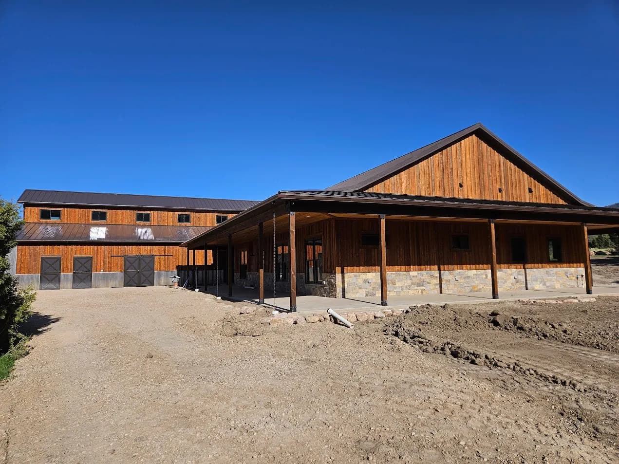 Dark seamless gutters on a large wood-sided barn home
